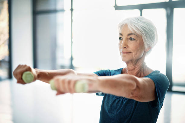 Cropped shot of a senior woman working out with dumbbells indoors Cropped shot of a senior woman working out with dumbbells indoors
